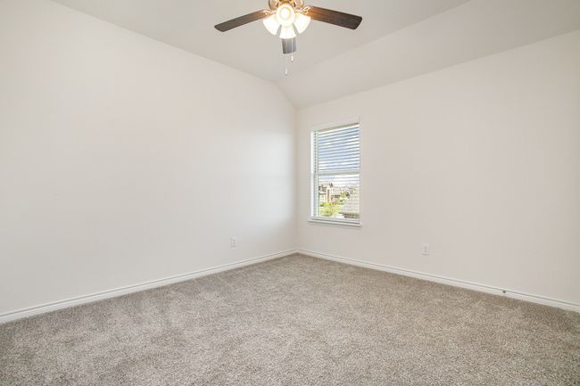 Empty room featuring ceiling fan, baseboards, vaulted ceiling, and carpet | Image 24