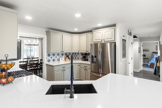 Kitchen featuring stainless steel refrigerator with ice dispenser, light countertops, recessed lighting, and tasteful backsplash | Image 33