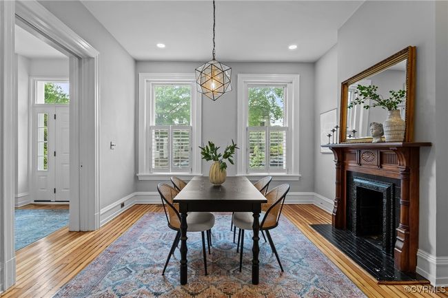 Dining area featuring wood-type flooring, a high end fireplace, and baseboards | Image 5