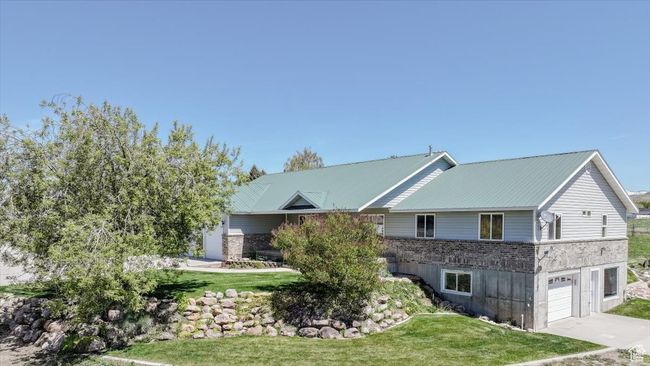 View of front of home featuring a front lawn, an attached garage, driveway, and brick siding | Image 7