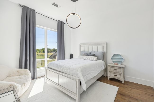 Bedroom featuring multiple windows and wood finished floors | Image 24
