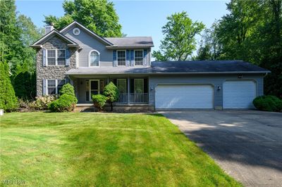 View of front facade with a garage, covered porch, and a front lawn | Image 1