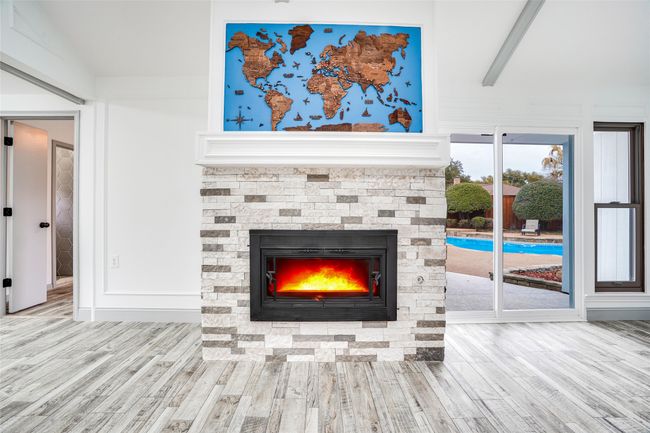 Detailed view of wood finished floors and a stone fireplace | Image 4