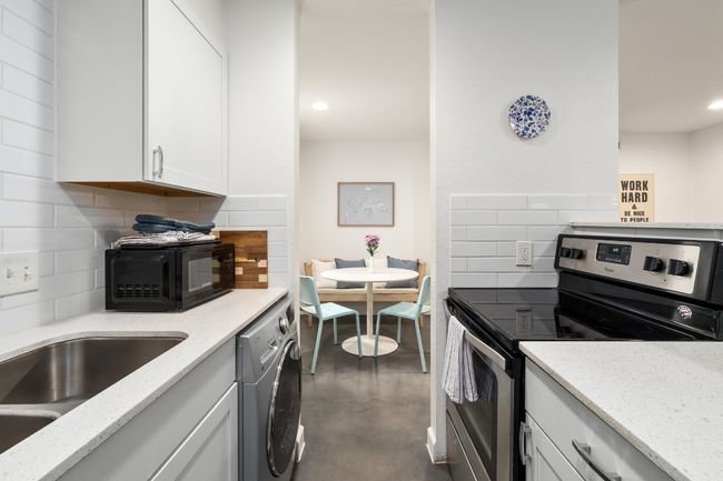 Kitchen with stainless steel electric range oven, black microwave, concrete flooring, decorative backsplash, and recessed lighting | Image 8