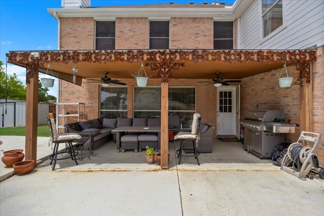 View of patio with ceiling fan, an outdoor living space, area for grilling, and an outbuilding | Image 32