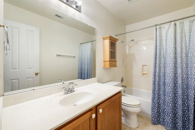Full bathroom with visible vents, tile patterned flooring, shower / tub combo, vanity, and toilet | Image 34
