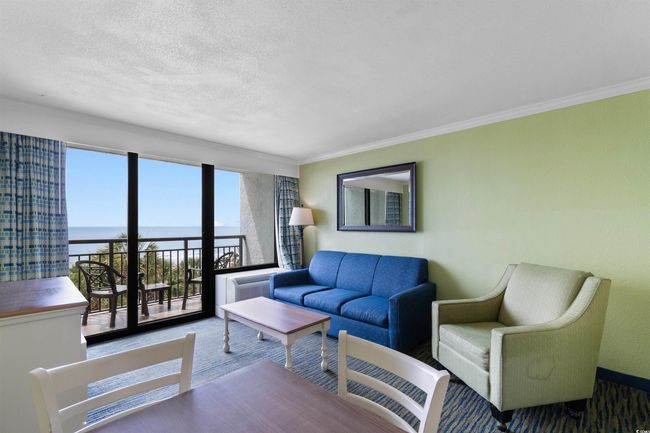 Carpeted living room with a water view, crown molding, and a textured ceiling | Image 4