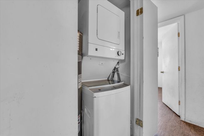 Laundry area featuring stacked washer and clothes dryer | Image 8