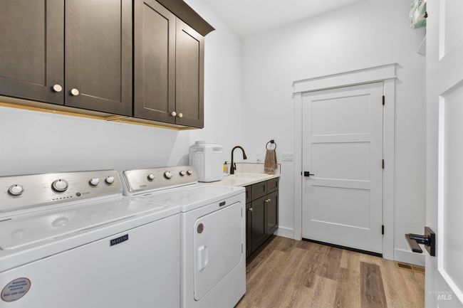 Laundry room featuring cabinet space, light wood-style floors, and washing machine and clothes dryer | Image 31