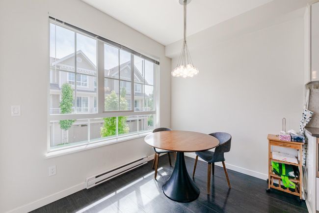 Dining room with a baseboard radiator, a chandelier, and dark wood-type flooring | Image 14