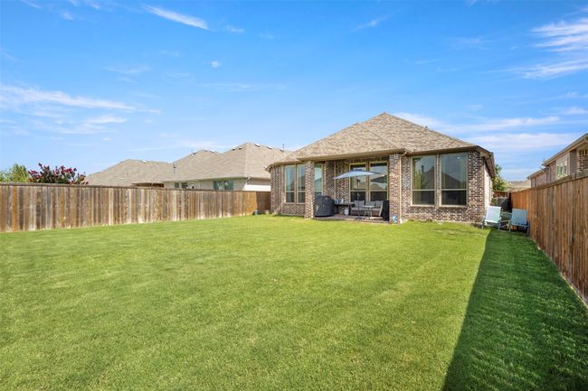 Rear view of property featuring brick siding, a fenced backyard, and a patio area | Image 30
