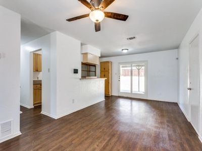 Unfurnished living room featuring ceiling fan and dark wood-type flooring | Image 2