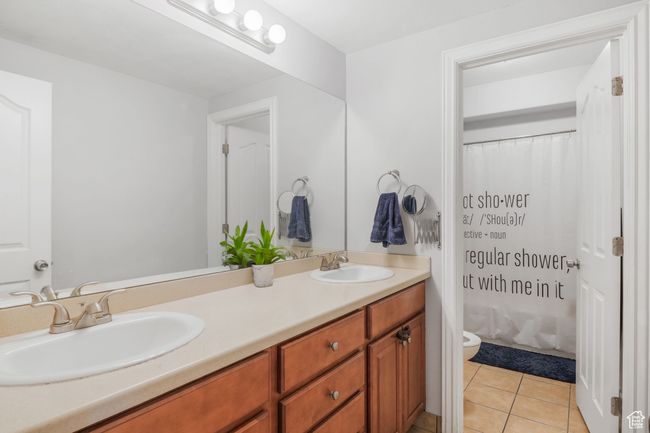 Full bathroom with toilet, double vanity, a sink, and tile patterned floors | Image 23