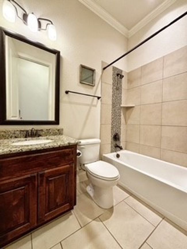 Bathroom featuring crown molding, vanity, bathing tub / shower combination, and tile patterned flooring | Image 16