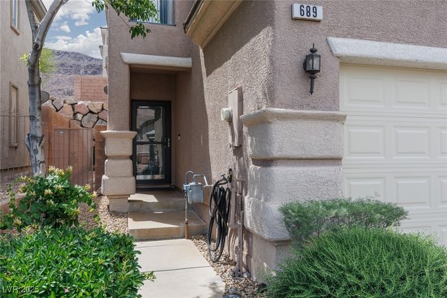 Entrance to property with a garage and stucco siding | Image 5