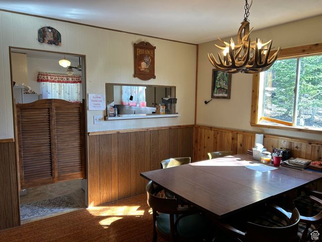 Dining space with a chandelier and wooden walls | Image 19