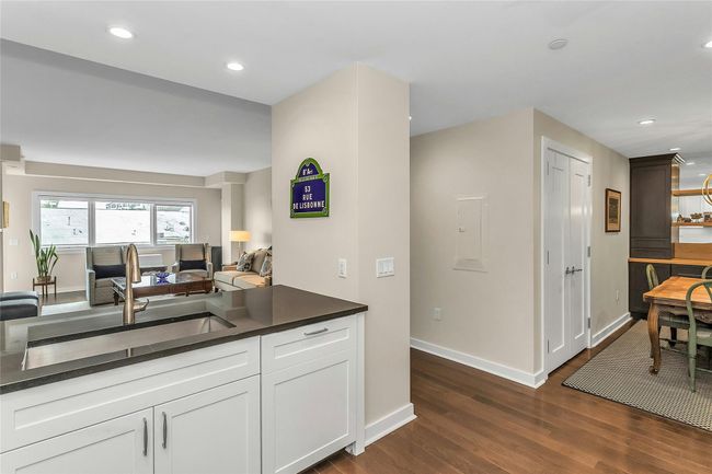 Kitchen with a sink, dark countertops, dark wood-type flooring, open floor plan, and baseboards | Image 6