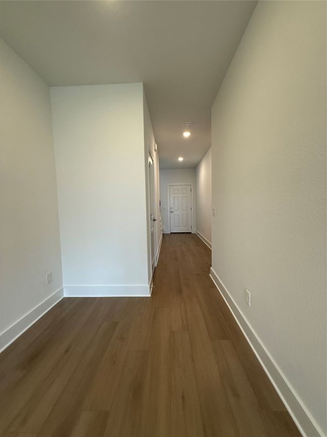 Hallway featuring baseboards and dark wood-style flooring | Image 22