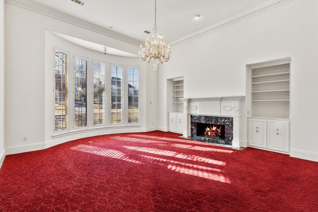 Non enhanced or virtually staged formal living with a wall of windows and fireplace | Image 15