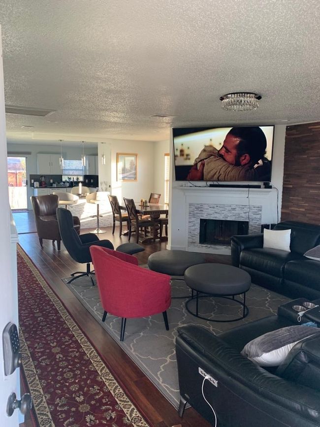 Living room with a textured ceiling, wood finished floors, and a high end fireplace | Image 15