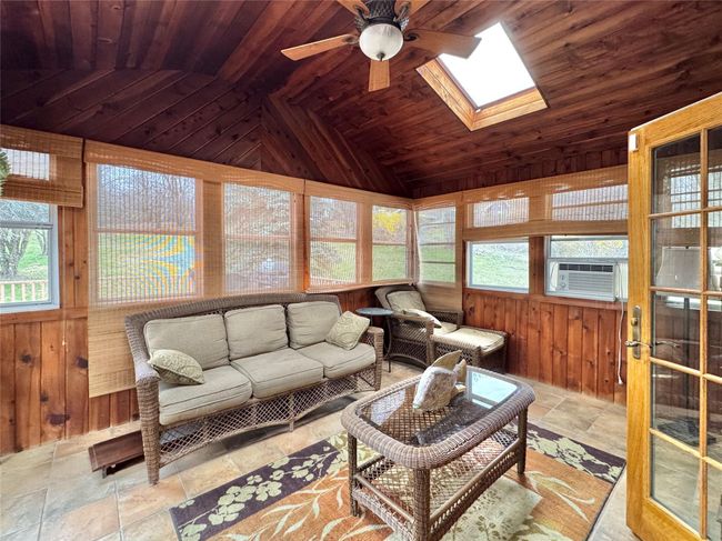 Living area featuring wooden walls, a ceiling fan, and wood ceiling | Image 13