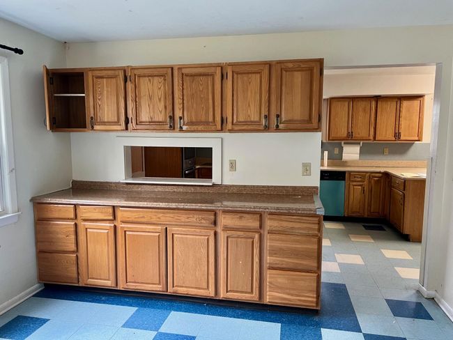 Kitchen featuring baseboards, open shelves, brown cabinets, light floors, and dishwashing machine | Image 19