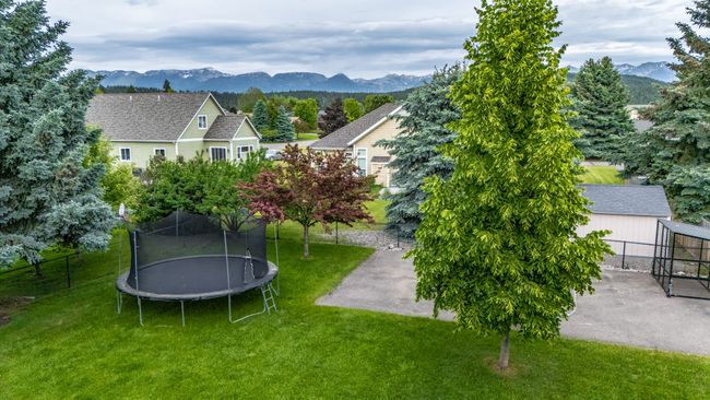 View of yard featuring a trampoline, a mountain view, and a patio | Image 21