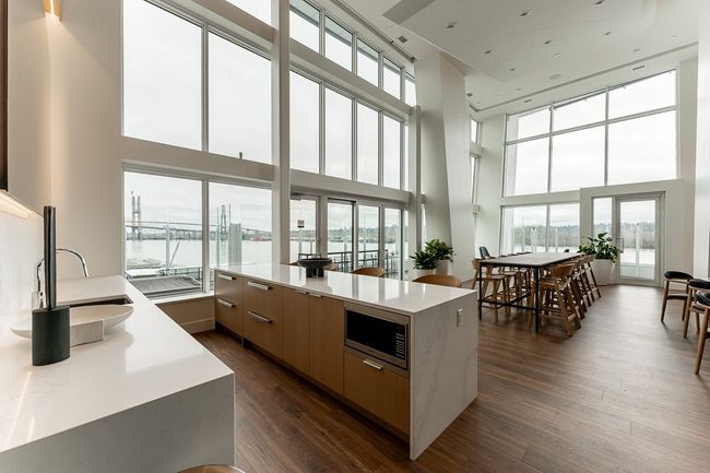 Kitchen featuring modern cabinets, stainless steel microwave, a sink, light countertops, and dark wood-style floors | Image 29