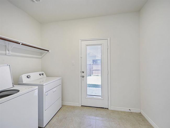 Laundry room featuring washing machine and clothes dryer and light tile patterned floors | Image 11