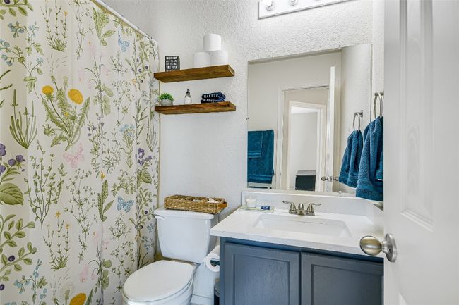 Full bathroom with vanity, a shower with curtain, and a textured wall | Image 16