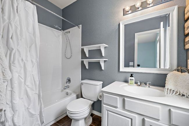 En suite full bath with shower / tub combo with curtain, toilet, vanity, and baseboards | Image 23