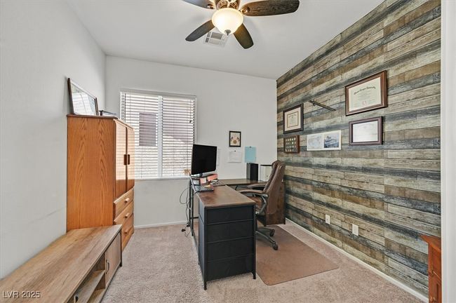 Home office featuring wood walls, an accent wall, carpet flooring, and a ceiling fan | Image 4
