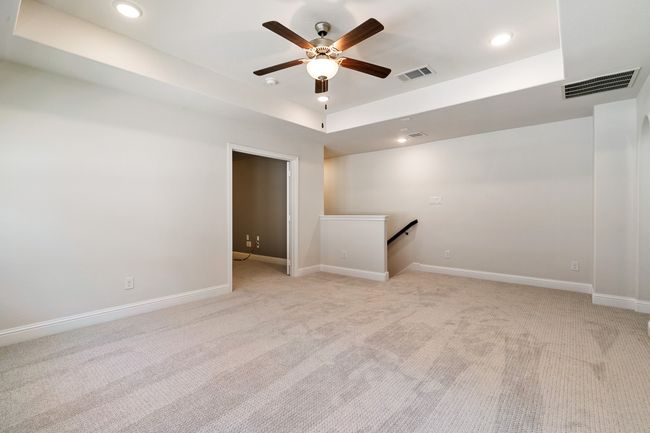 Spare room with a tray ceiling, baseboards, visible vents, and ceiling fan | Image 23