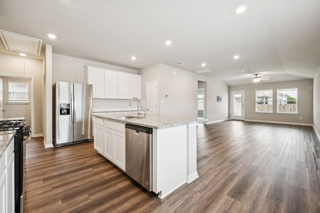 Kitchen with appliances with stainless steel finishes, a ceiling fan, dark wood-type flooring, a center island with sink, and recessed lighting | Image 4