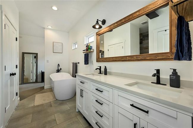 Bathroom with double vanity, a freestanding bath, and tile patterned floors. Quartz countertops | Image 27
