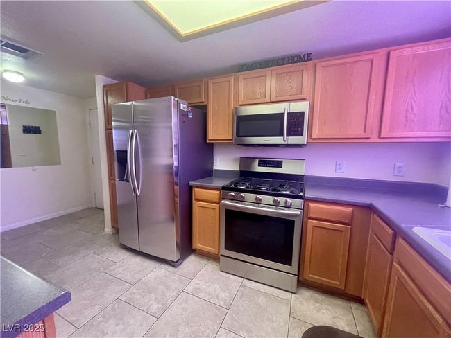 Kitchen with visible vents, dark countertops, and stainless steel appliances | Image 9