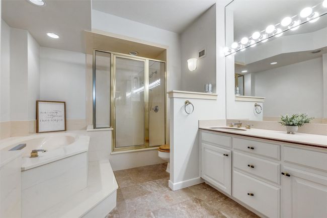 Bathroom featuring a stall shower, a bath, vanity, and toilet | Image 6