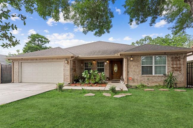This image shows a single-story brick home with an attached two-car garage, manicured lawn, and a welcoming entryway. | Image 5