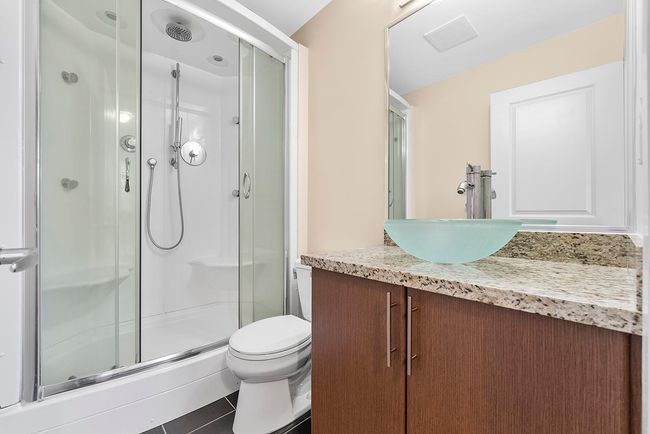Full bathroom featuring tile patterned flooring, a shower stall, toilet, and vanity | Image 6