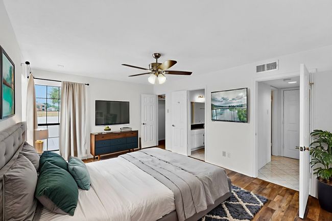 Virtually staged bedroom featuring wood finished floors, a ceiling fan, and ensuite bath | Image 19