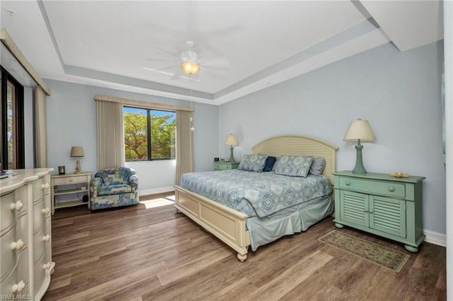 Bedroom featuring a tray ceiling, wood finished floors, and a ceiling fan | Image 18