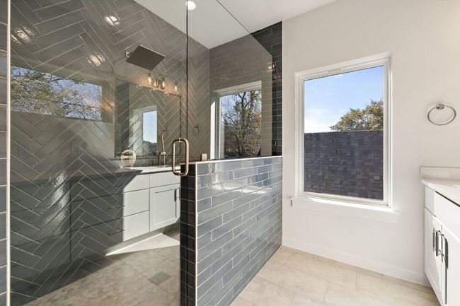 Bathroom featuring a tile Primary shower, a wealth of natural light, and vanity | Image 28