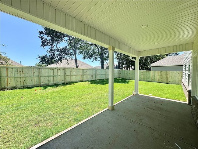 Large covered patio area to relax on overlooking the fenced in backyard. | Image 21