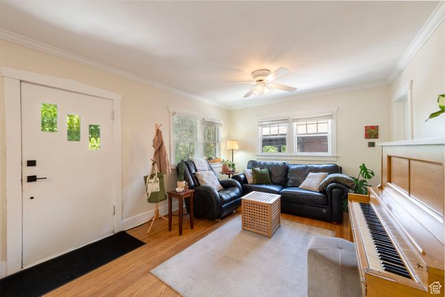Living room with ornamental molding, wood finished floors, and ceiling fan | Image 5