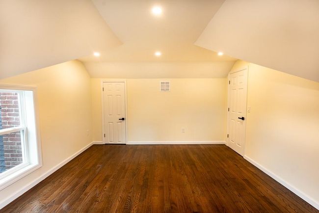 Master bedroom on second floor featuring dark wood finished floors, visible vents, baseboards, and lofted ceiling | Image 25