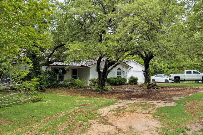 View of side of home with an attached garage, a standing seam roof, and metal roof | Image 24