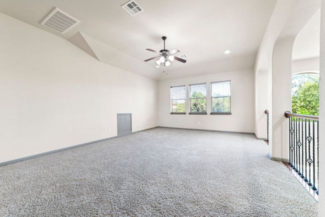 Spare room with plenty of natural light, light colored carpet, a ceiling fan, arched walkways, and lofted ceiling | Image 31