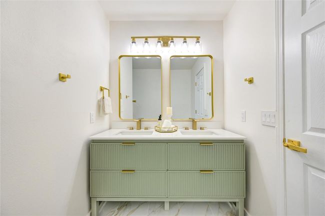 The primary bathroom features a sleek and spacious double vanity, offering plenty of room for two. The vanity is topped with Quartz countertops, providing a durable and elegant surface that complements the modern design. | Image 20