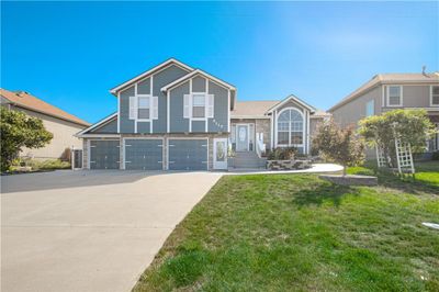 View of front facade with a garage and a front yard | Image 1