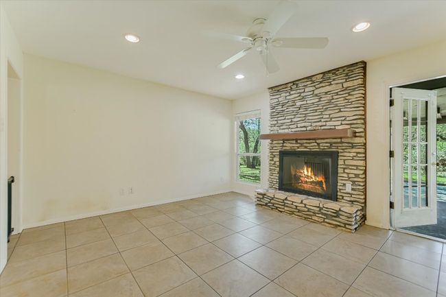 Unfurnished living room with tile patterned flooring, a fireplace, a ceiling fan, recessed lighting, and baseboards | Image 4
